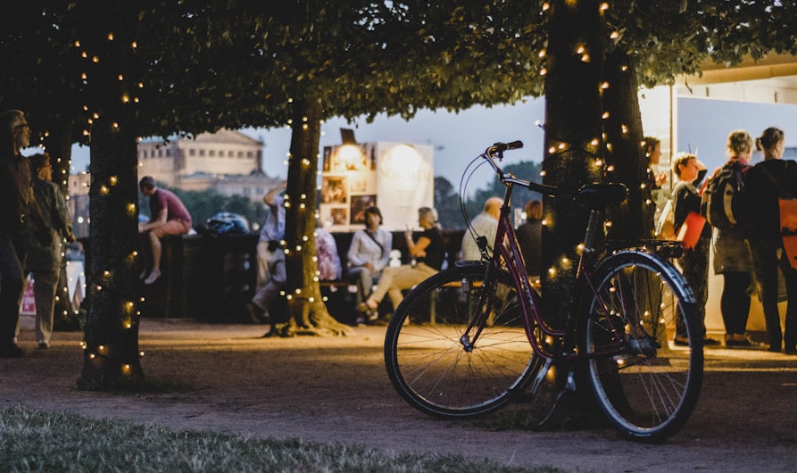 shallow focus photography of bike parked beside tree